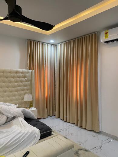 Curtains hung over a voile by KD Dream Space Designs